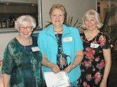 Elene Fellman and Mary Ellen Gabel presenting Ole to Karen Holmquist (center)
