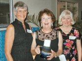 Carolyn Buswell and Mary Ellen Gabel presenting Ole to Gloria Dombrock (center)